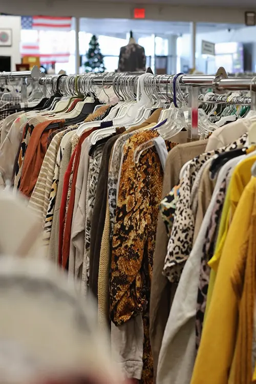 Clothing racks filled with gently used apparel inside Value Village Thrift Store.