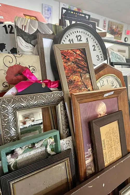 Selection of framed artwork, mirrors, clocks, and home décor available at Value Village Thrift Store.