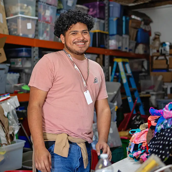 Team member smiling while sorting donated items at Value Village Thrift Store.